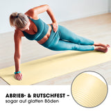 Frau trainiert auf #DoYourFitness Fitnessmatte Hell Beige 183x61x1,5 cm rutschfest für Yoga und Gymnastik innen und außen.