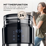 Barista Filterkaffeemaschine Grind mit Mahlwerk, LED-Touchdisplay & Timer zeigt Uhrzeit und Bedienelemente mit Frau im Hintergrund.
