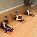 Drei Frauen dehnen sich auf Yogamatten mit #DoYourYoga Yogagurt Amita mit stabilem Metall-Ring-Verschluss in Schoko, 260 x 3,8 cm.
