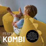 Kind entspannt auf LUMALAND Animal Line Kindersitzsack Dino - Senfgelb, weich, robust und wasserabweisend für gemütliche Stunden.