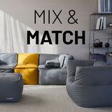 LUMALAND Sitzsack-Sofa Mittelstück senfgelb kombiniert mit modularen grauen Elementen in modernem Wohnzimmer.