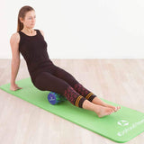 Frau nutzt #DoYourFitness Faszienrolle Anila eckig 45x15 cm Schwarz/Rot für Tiefenmassage und Faszientraining auf Yogamatte.